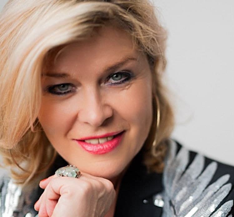 Porträt von Michaela Gruber mit rotem Lippenstift und goldenen Creolen
